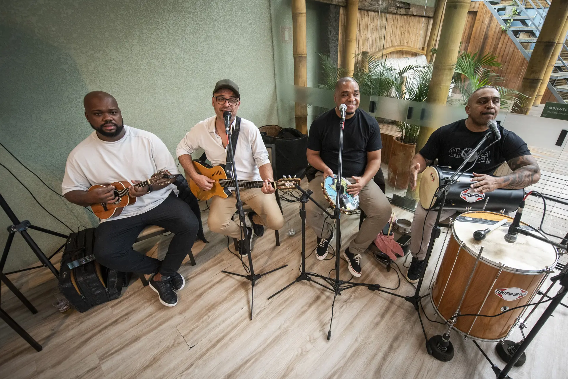Grupo de convidados cantando parabéns em volta da mesa do bolo com balões