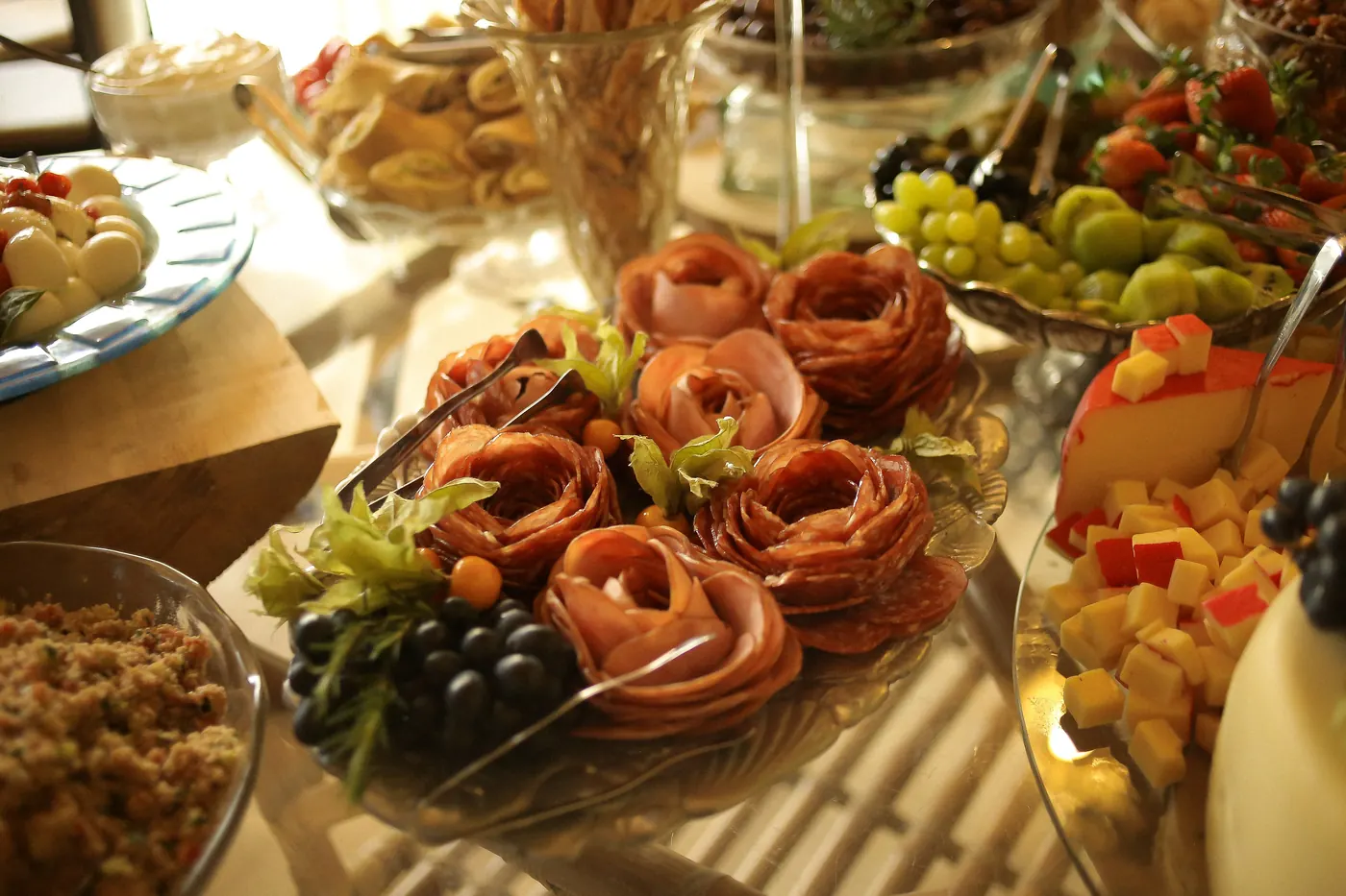 Buffet de frios e queijos com uvas e presunto em formato de rosas