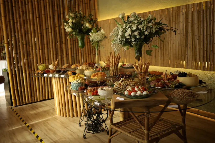 Mesa de antepastos completa com arranjos de flores
