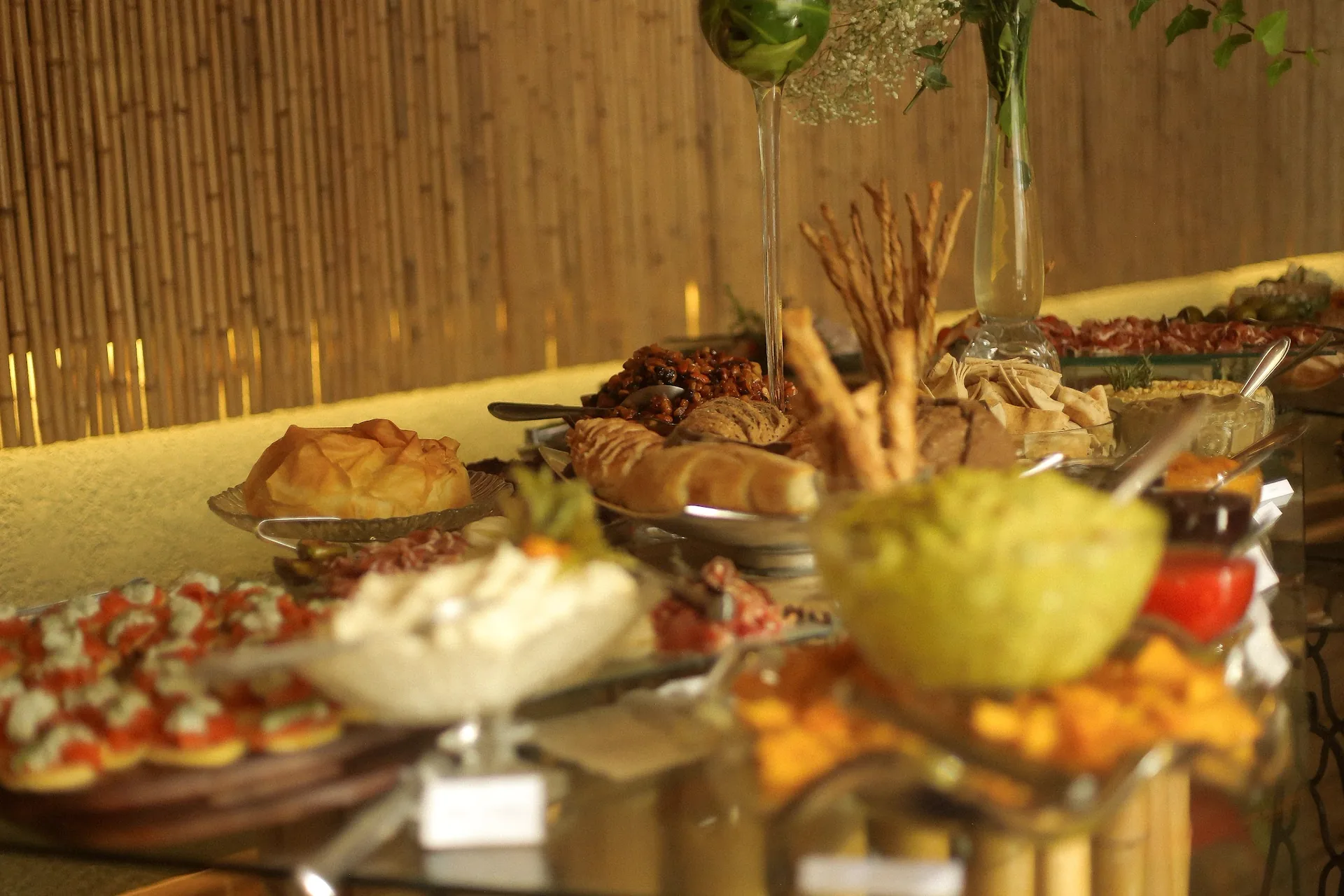 Buffet com variedade de pães, frios, frutas e queijos