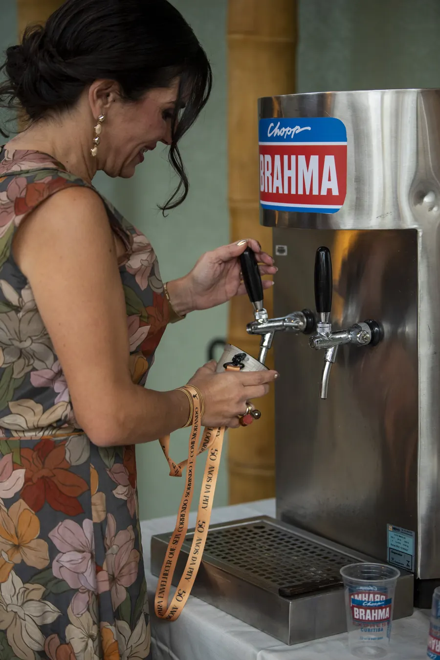 Convidada servindo chopp na chopeira com copo personalizado