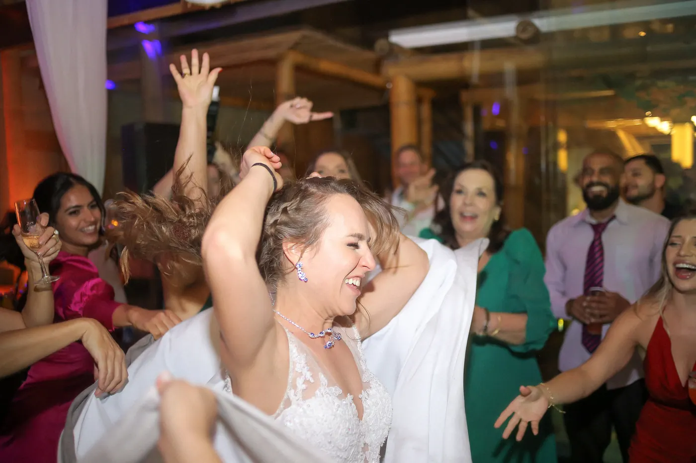 Noiva em roda de amigas dançando animadas com vestidos coloridos